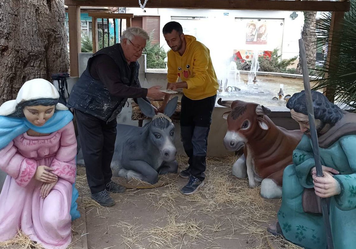 Ramón Espinosa y Pedro Mascarell, reparando la mula del pesebre.