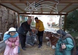 Ramón Espinosa y Pedro Mascarell, reparando la mula del pesebre.