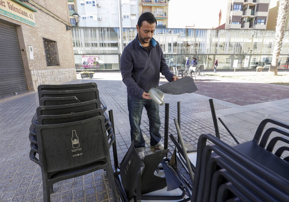 Aldo Pattini, encargado del local de Alboraya, sostiene un resto de retrovisor entre sus sillas rotas.