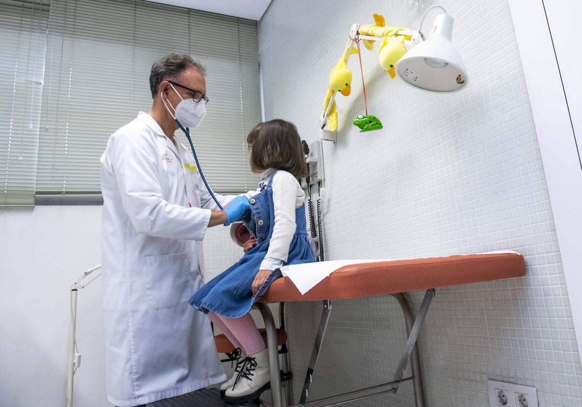 Un pediatra atiende a una niña en la consulta.