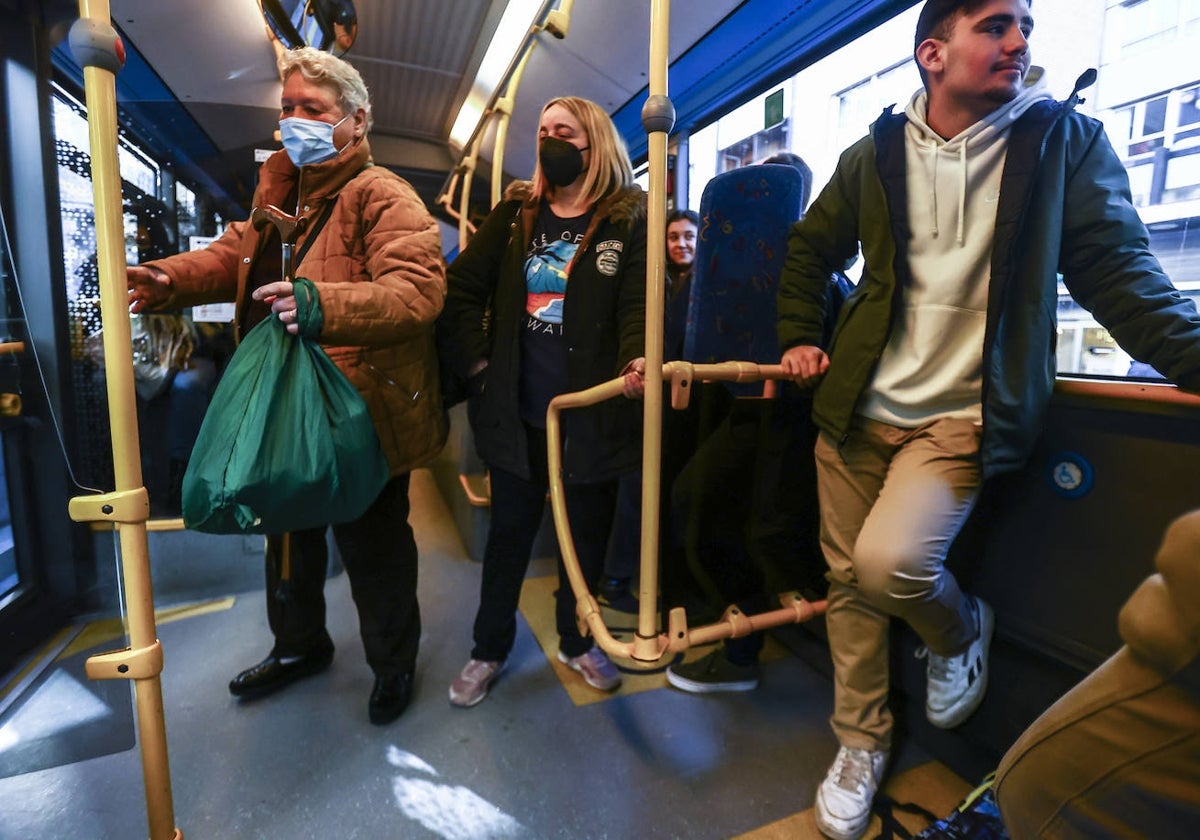 Pasajeros en un autobús, algunos con mascarilla.