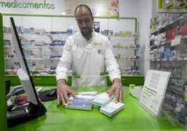 Un farmacéutico con varios test de Covid.