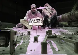 Activistas que realizaron el acto de protesta en Expojove tiñendo de rosa un tanque del Ejército de Tierra.