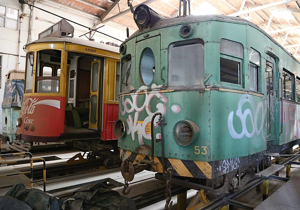 En primer plano, un trenet Devis número 53 que sigue en los talleres de Torrent en espera de su restauración, según FGV. Al lado, un tranvía lisboeta ofrecido a la Generalitat en 1995.