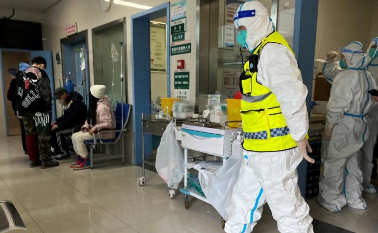 Un personal de seguridad con un traje protector vigila mientras los médicos atienden a los pacientes en el Hospital Tongji, en Wuhan. 