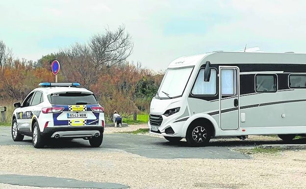 Una patrulla de la Policía Local, junto a una autocaravana. 