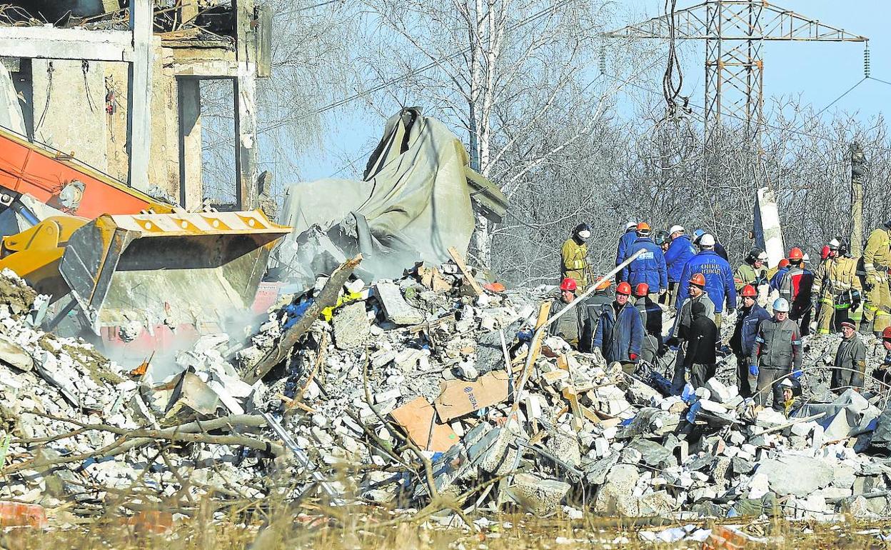 Trabajadores retiran los escombros del edificio destruido en búsqueda de supervivientes.