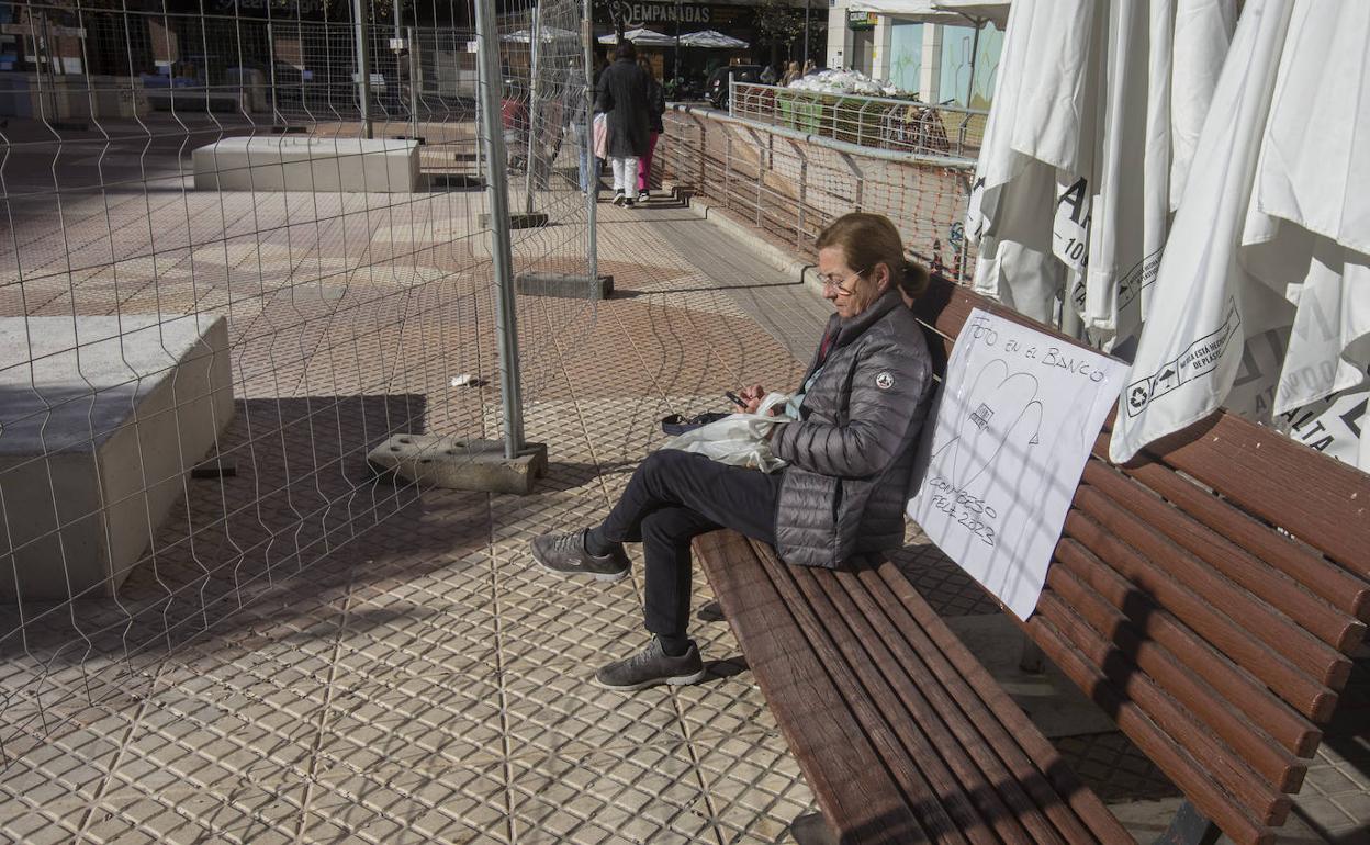 Una señora, sentada en uno de los bancos de la plaza Polo Bernabé.