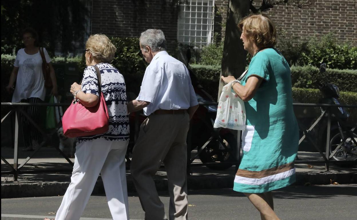 Un grupo de ancianos, cruzan un paso de peatones en una calle