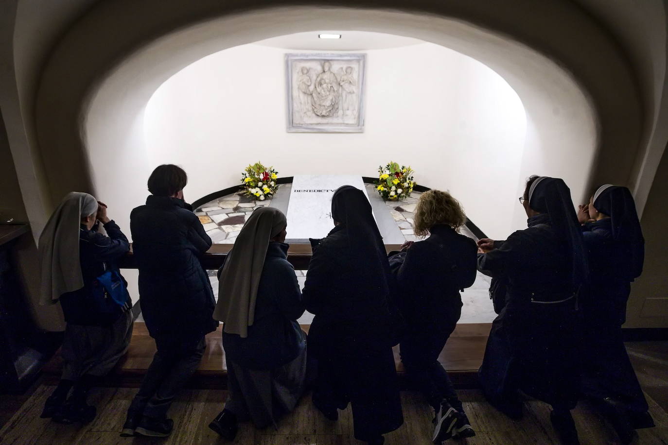 Tal y como estaba previsto, después de las obras efectuadas para la introducción en la cripta del ataúd, las puertas de este área situada en los sótanos de la basílica de San Pedro han reabierto de nuevo a los turistas y los fieles. Los restos mortales de Benedicto XVI, que reposan en un ataúd triple, el primero elaborado con madera de ciprés, el segundo de zinc y el tercero de roble, junto con algunos objetos personales, como las medallas acuñadas durante su pontificado o un pergamino con los hechos más destacados de su vida como la lucha contra los abusos sexuales, fueron trasladados este jueves hasta las grutas vaticanas después de su funeral oficiado por el Papa Francisco en la plaza de San Pedro del Vaticano.