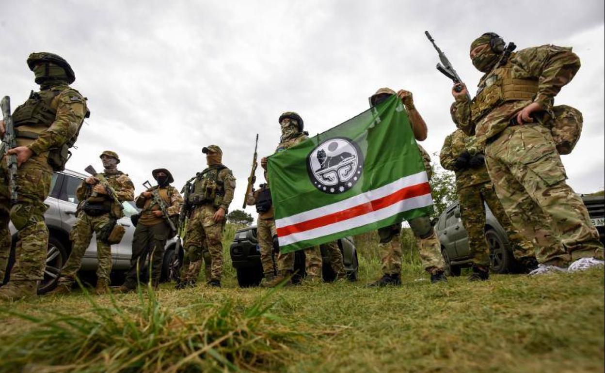 Voluntarios del Batallón Dzhokhar Dudayev posan con una bandera de la llamada República Chechena de Ichkeria, durante un ejercicio militar cerca de Kiev el 28 de agosto de 2022.