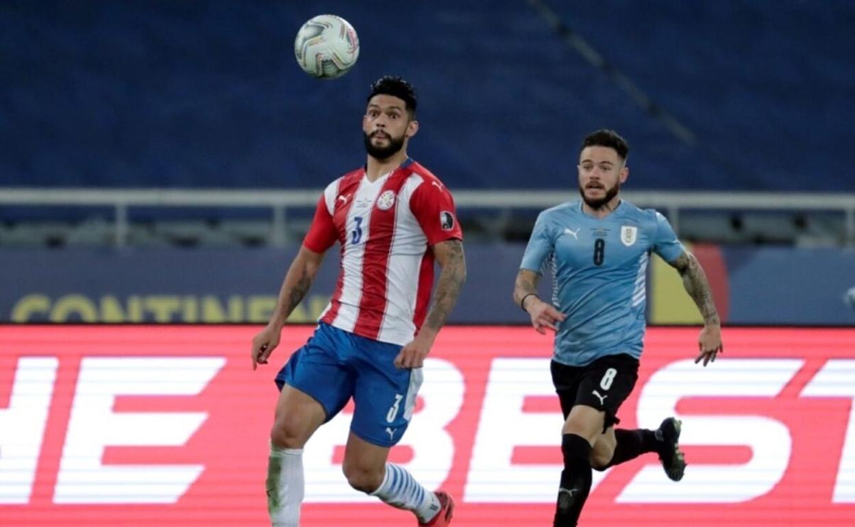 Nahitan Nández, con el dorsal ocho, persigue a Alderete durante un partido entre Paraguay y Uruguay. 