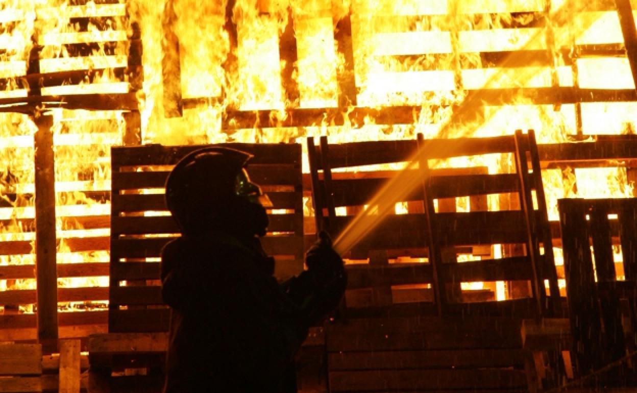 Un bombero apagando una hoguera en Alzira. 