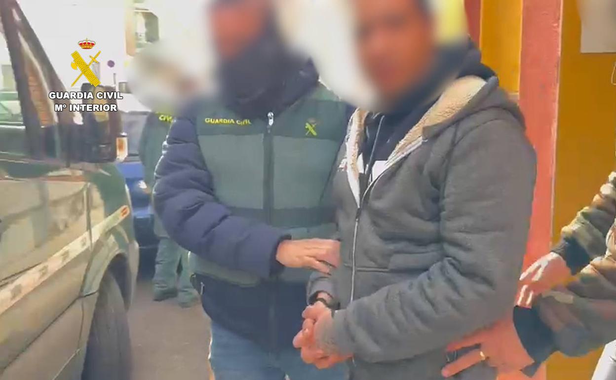 Una agente con uno de los detenidos en la operación. 