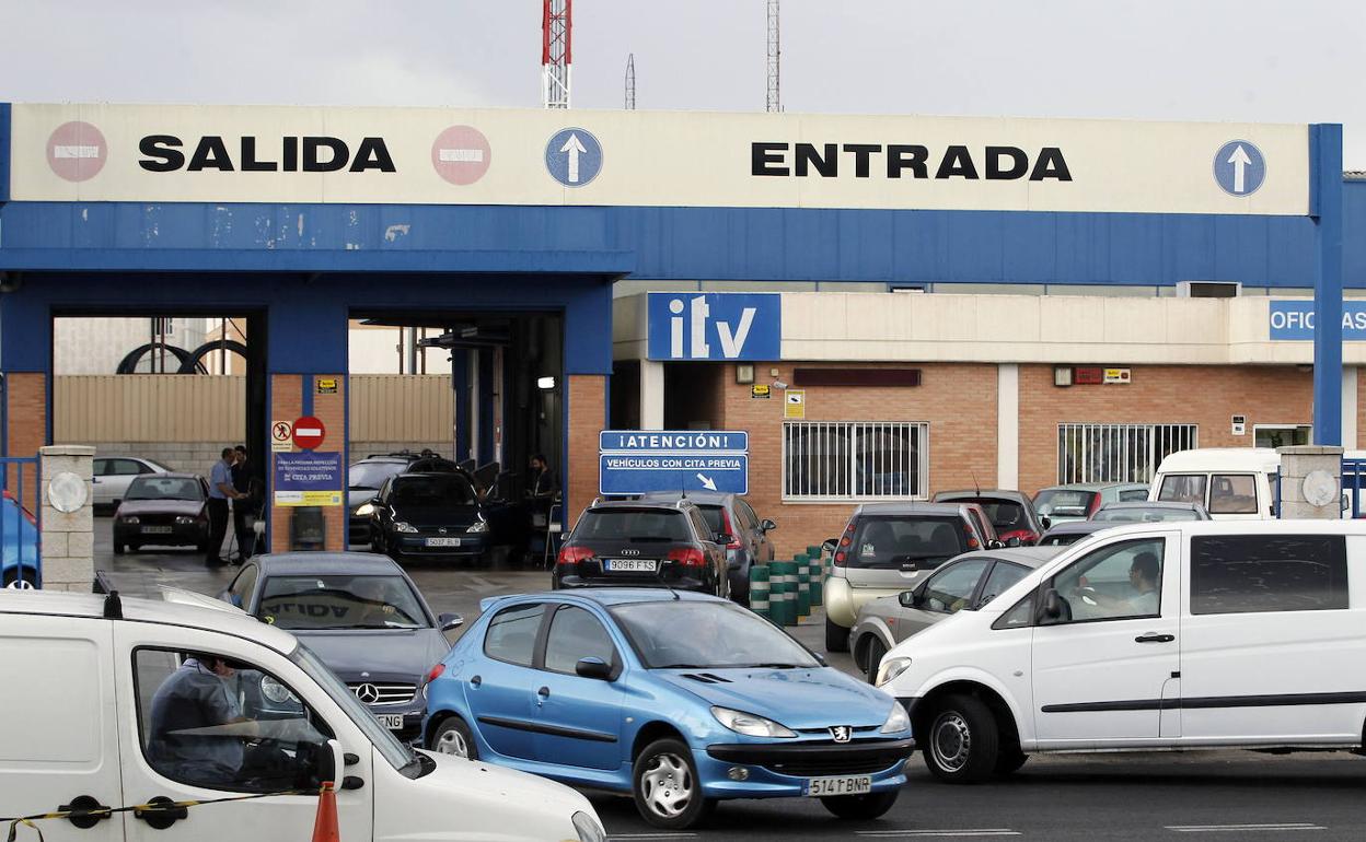 Varios coches hacen cola en una estación de ITV. 