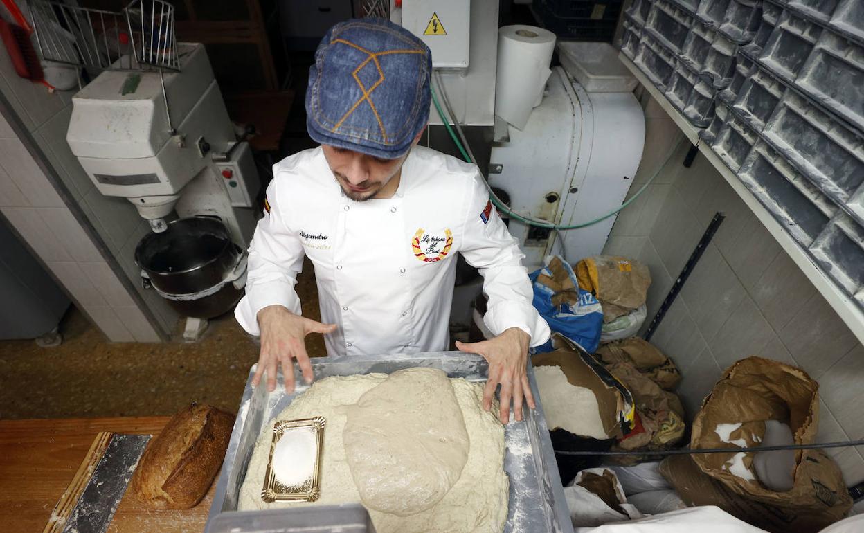 Un panadero elabora pan con masa madre. 