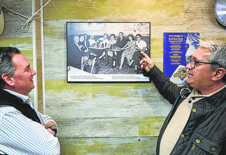 Juan Carlos y Fernando contemplan una foto de 1959 que se encuentra en el Bar March.