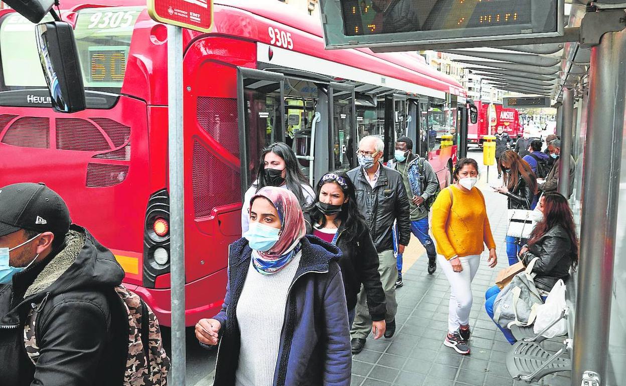 Varios pasajeros bajan de un autobús de la EMT en plena pandemia.