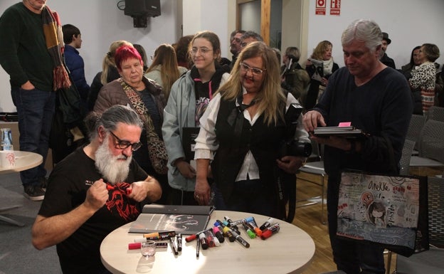 El ilustrador y uno de los autores del cómic  firmando libros tras la presentación. 