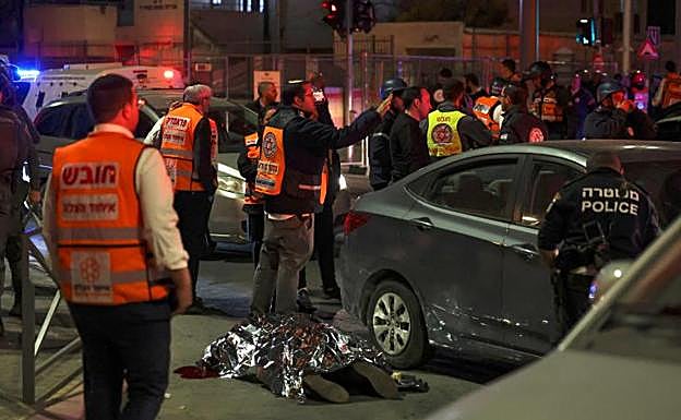 Los servicios de emergencia cubren el cuerpo de una víctima tras el ataque a una sinagoga. 