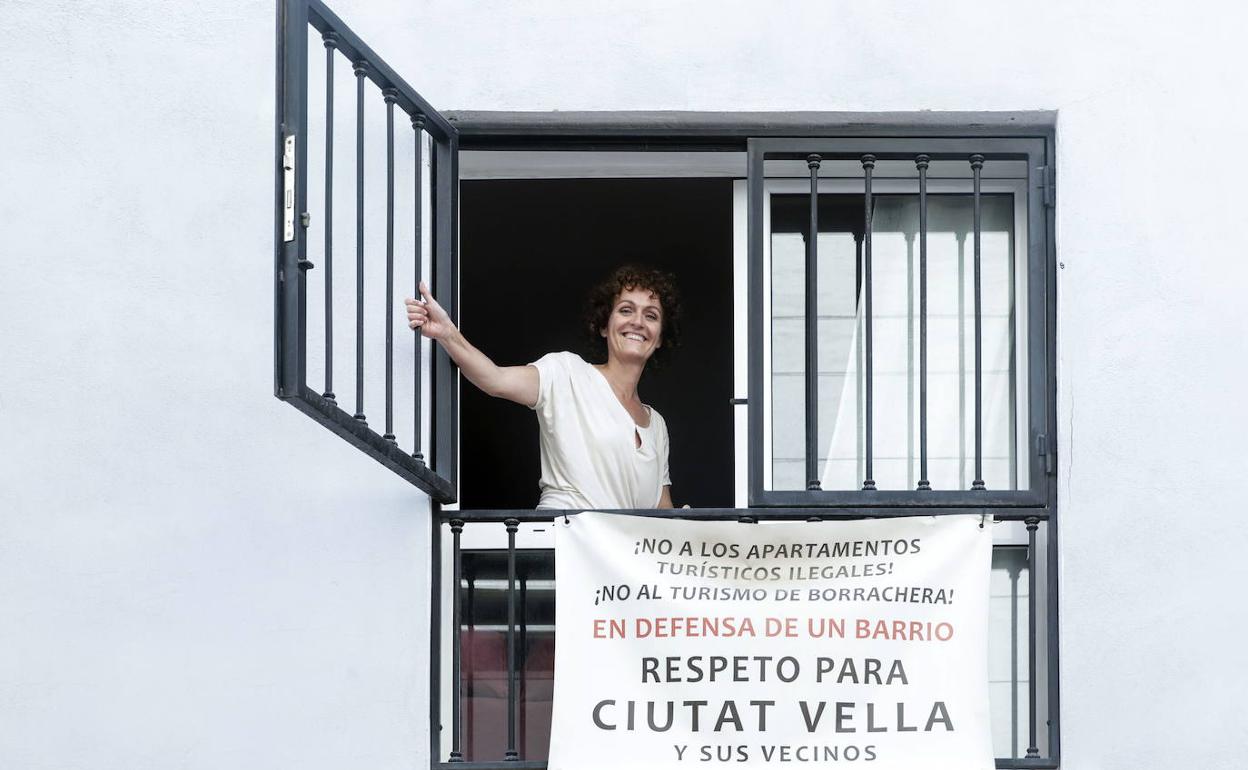 Una vecina, con un cartel contra los apartamentos turísticos ilegales en Ciutat Vella. 