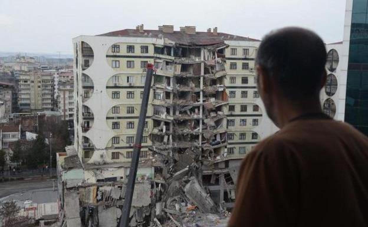 Un hombre observa las operaciones de búsqueda entre los restos de un edificio en Diyarbakir (Turquía)