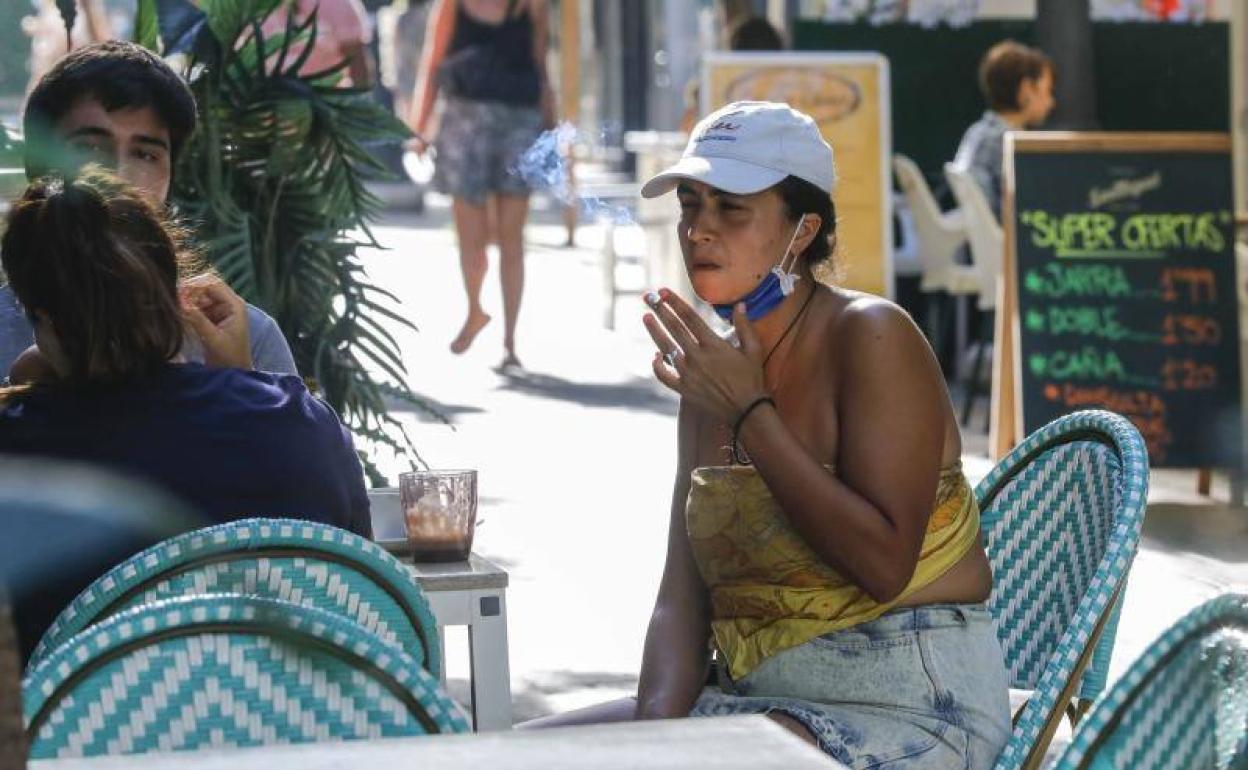 Clientes fumando en una terraza de Valencia. 