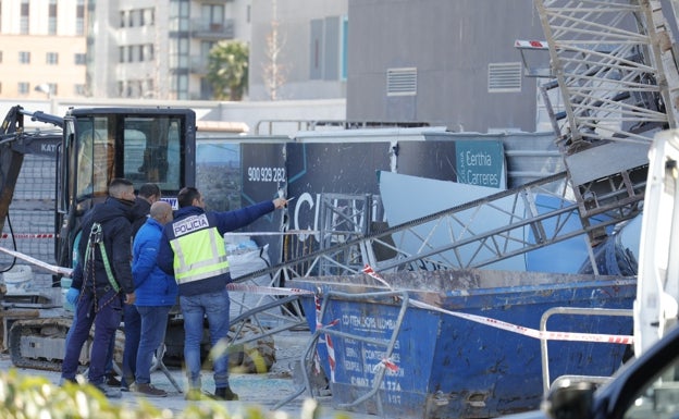 Policías y técnicos inspeccionan el andamio desplomado.  