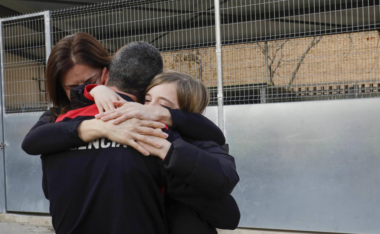 Uno de los bomberos se abraza a su mujer y a su hijo. 