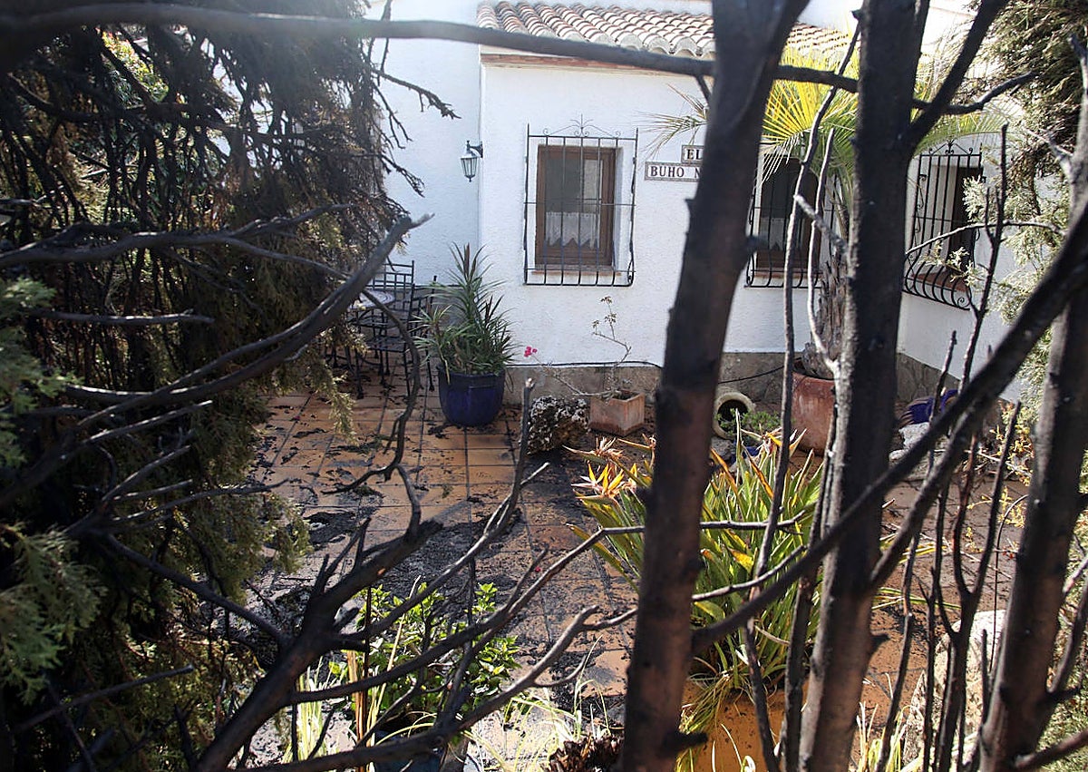 Imagen secundaria 1 - Constantine van Heften barriendo los restos de cenizas y los daños en una de las casas.