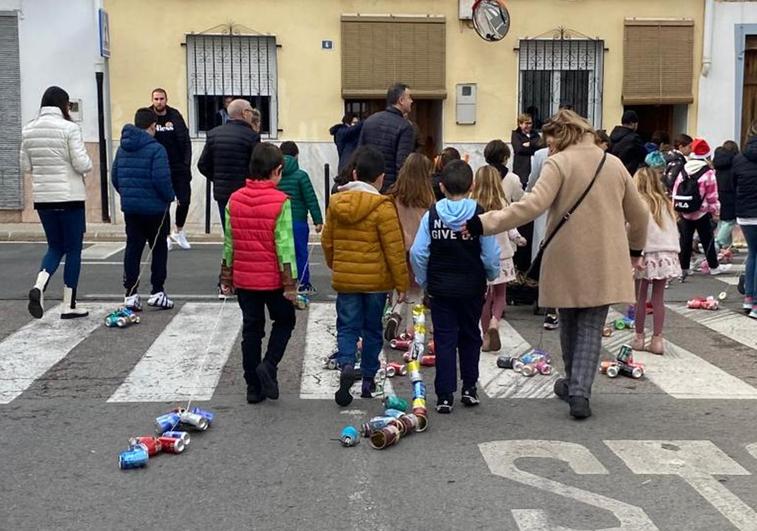 Los niños, con las latas.