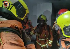 Efectivos de bomberos extinguen un incendio en un párking en Xirivella.