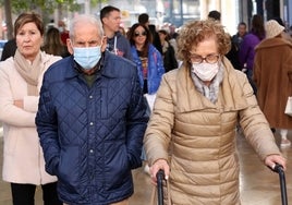 Una pareja de ancianos camina por el centro de Valencia con mascarilla.