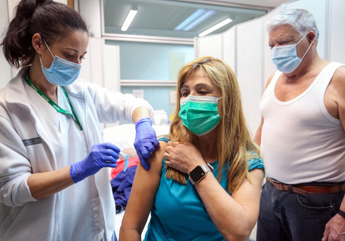 Una enfermera vacuna a una mujer contra la gripe y el Covid este lunes en Valencia.