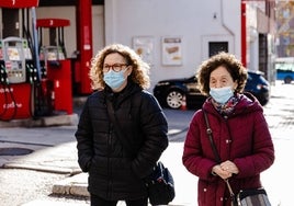 Dos mujeres con mascarilla por la calle.