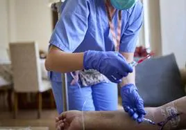 Una enfermera atiende a un enfermo.