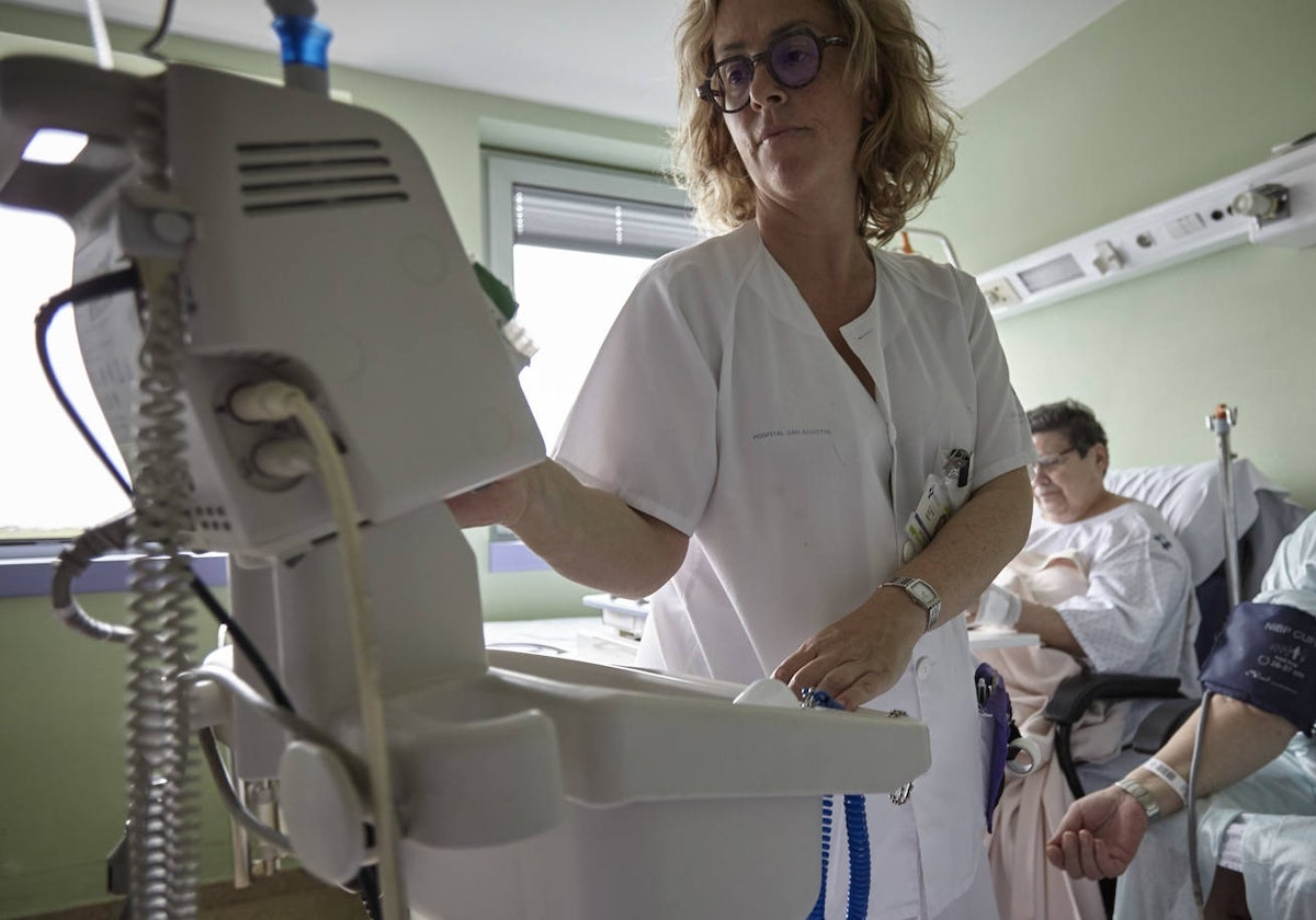 Una enfermera junto a dos pacientes.