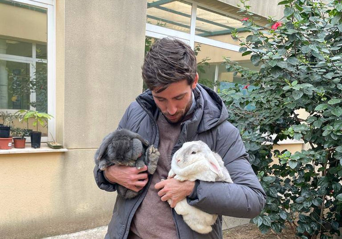 Juan Carlos Caballero con dos conejos rescatados.