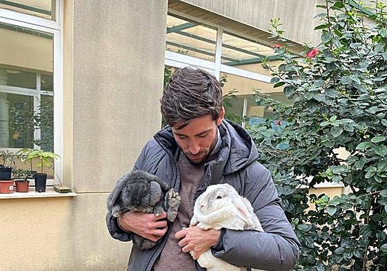 Juan Carlos Caballero con dos conejos rescatados.