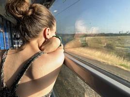 Una joven mira por la ventana durante un viaje en tren. Imagen de archjvo.