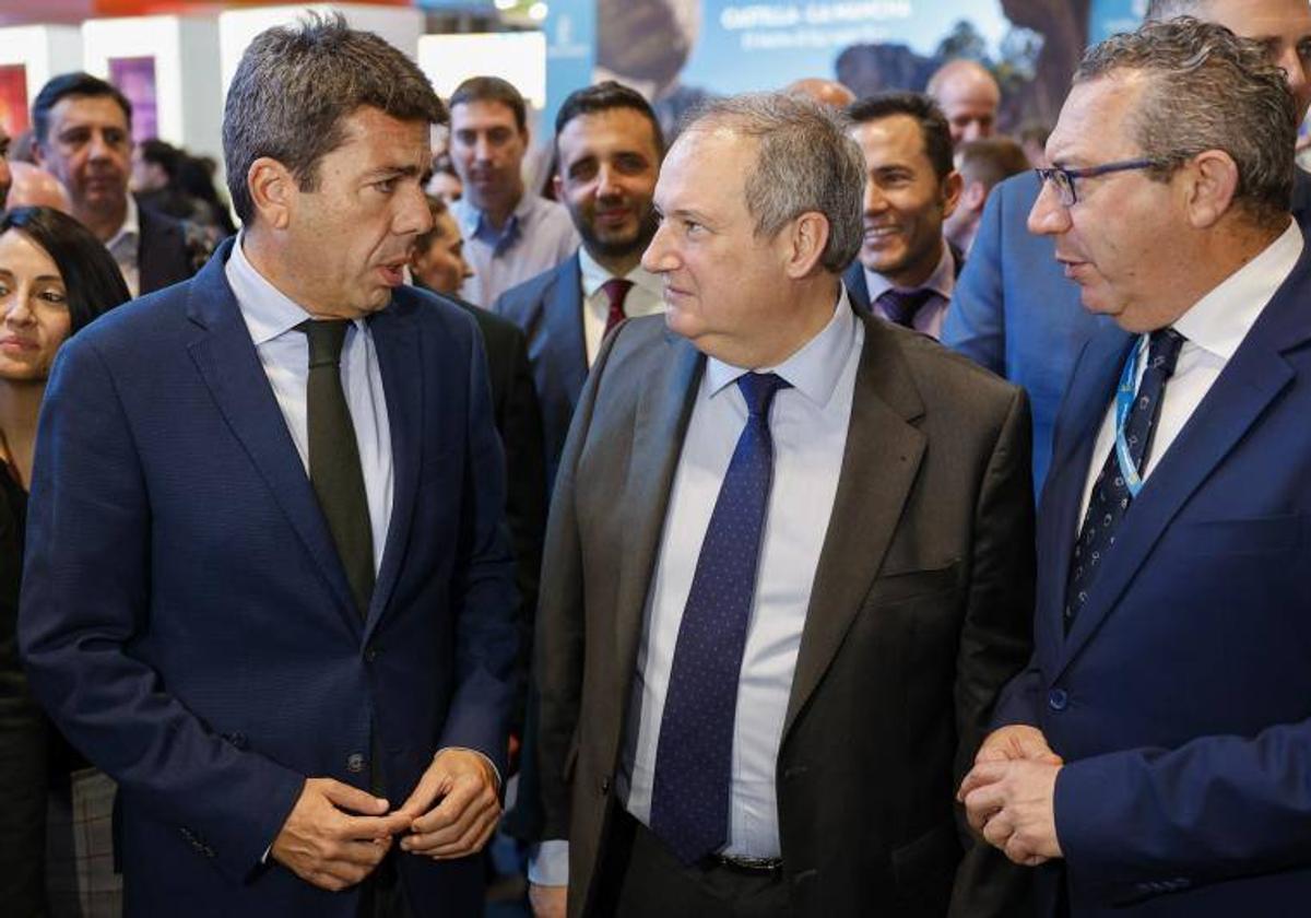 El ministro de Industria y Turismo, Jordi Hereu (c), conversa con el president de la Generalitat, Carlos Mazón, y el president de la Diputación de Alicante, Toni Pérez (d), durante su visita los expositores de las marcas turísticas y empresas de Alicante, Castellón y Valencia con motivo del Día de la Comunitat Valenciana en Fitur 2024.