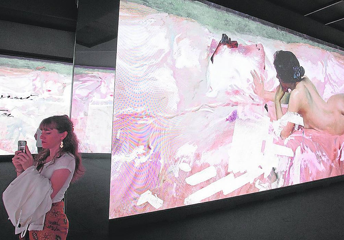 Una mujer se fotografía con la imagen digitalizada de la obra de Sorolla en Bancaja.