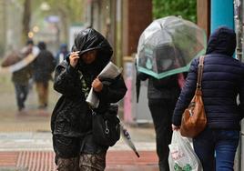 Varios viandantes se refugian de la lluvia.