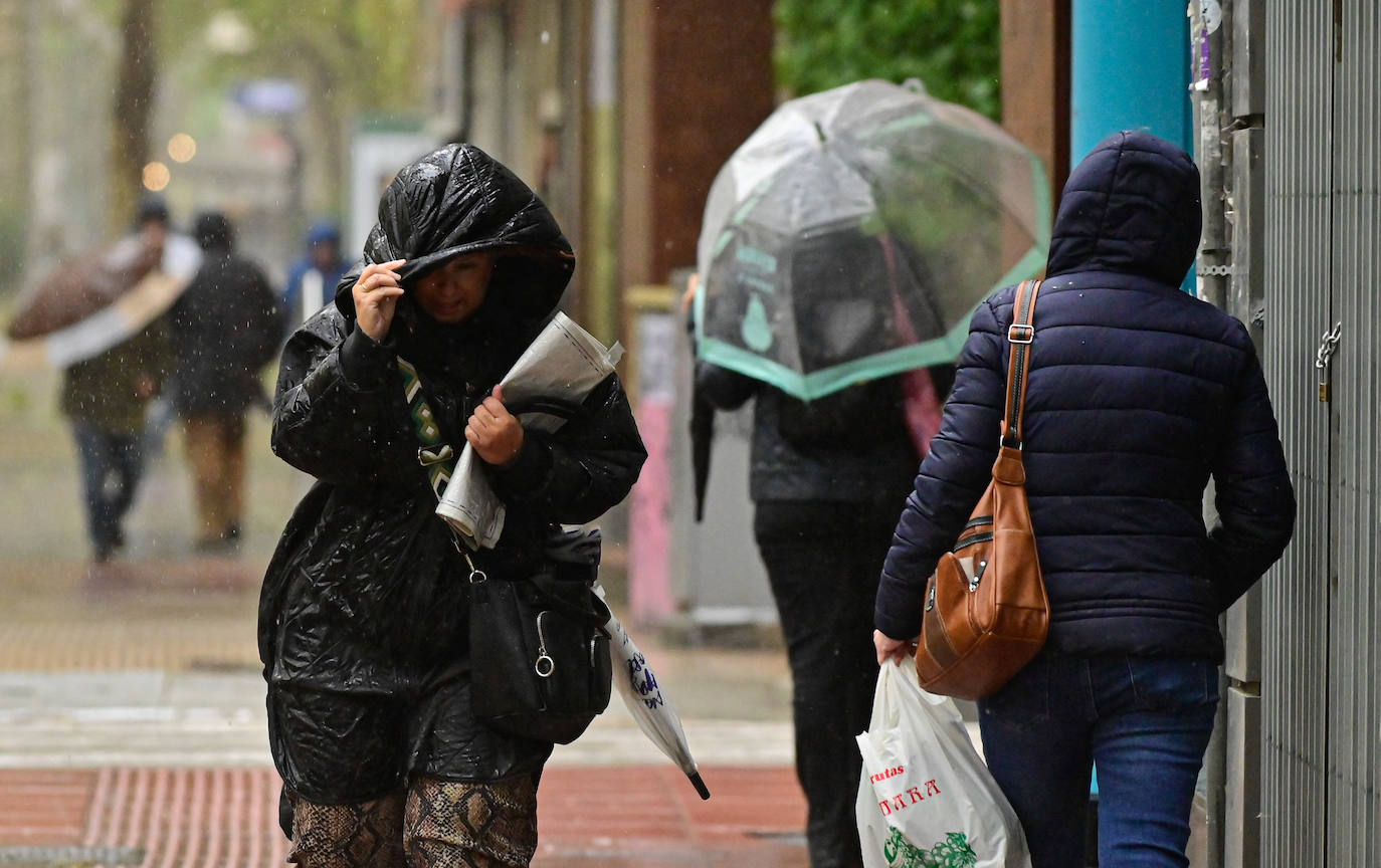 Varios viandantes se refugian de la lluvia.