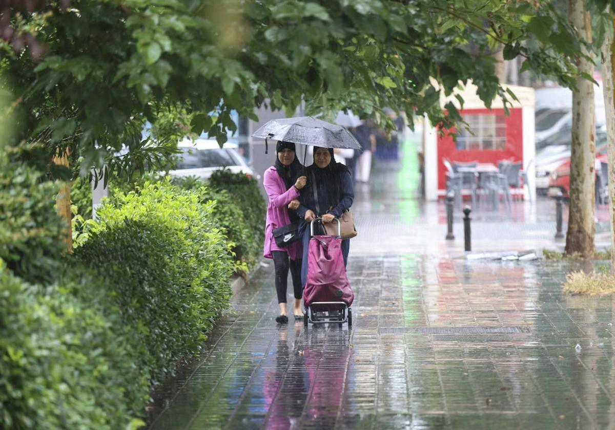 Una pareja se resguarda de la lluvia con un paraguas en Valencia.