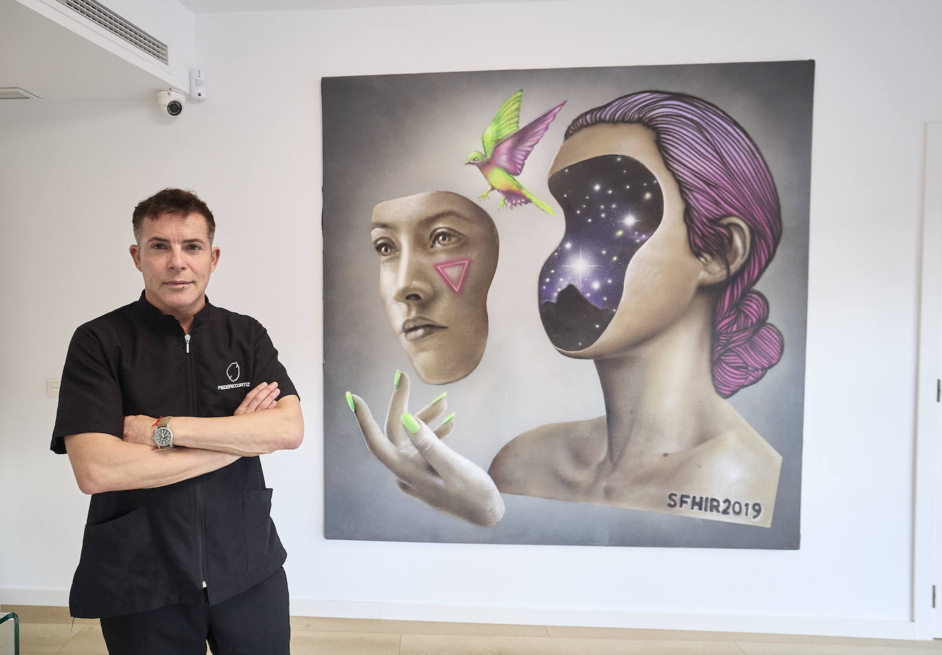 El médico Federico Ortiz, delante del lienzo de Sfhir en la clínica de estética de Valencia.