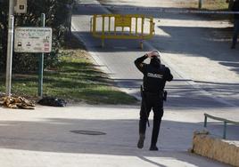 Un policía, junto a unas mantas junto a las que fue encontrado el indigente herido a pedradas en el viejo cauce.