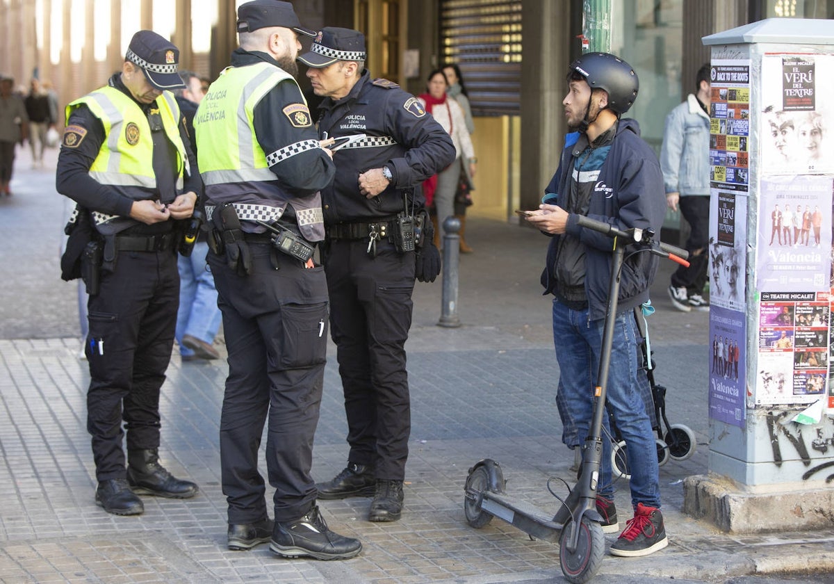 Los policías con un usuario de patinete en el control este lunes.