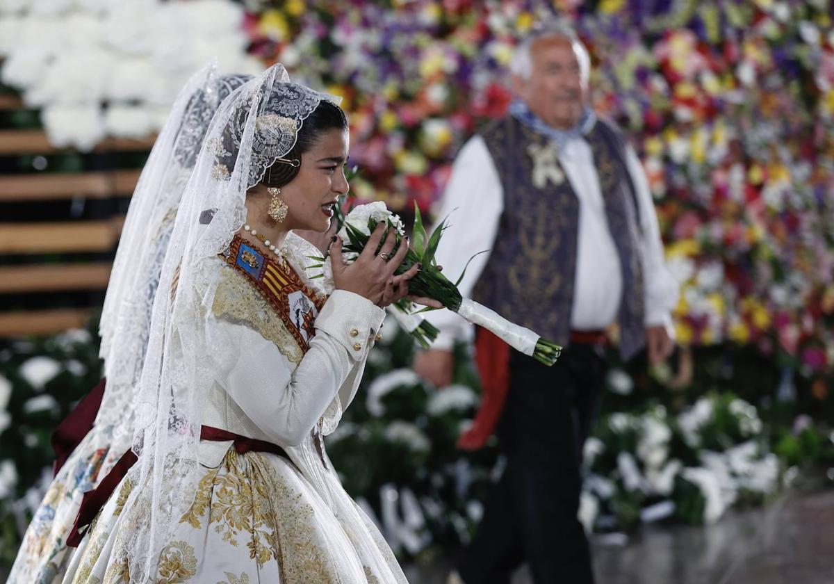 Una fallera se emociona y besa el ramo que le va a entregar a la Virgen de los Desamparados en la Ofrenda de las Fallas de 2023.