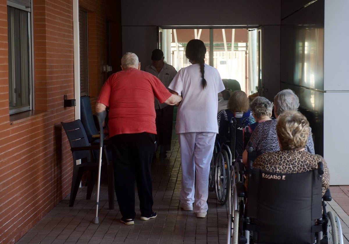 Varios ancianos en una residencia junto a una sanitaria.